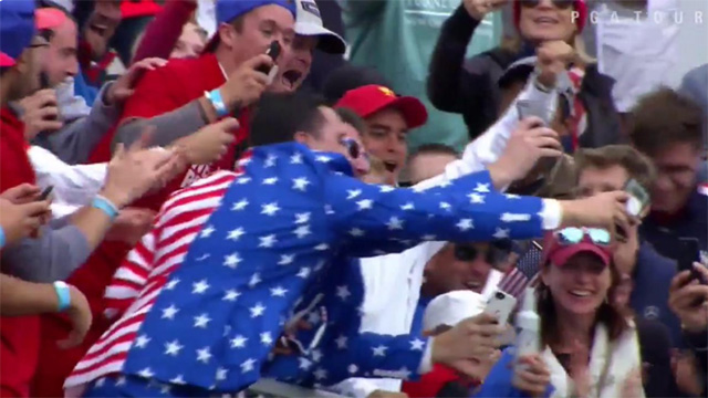 Rickie Fowler joins U.S. Team fans on the first tee at the Presidents Cup 