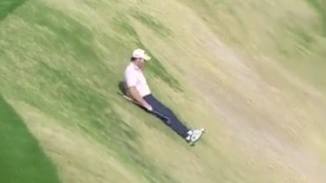 Grayson Murray playfully slides down hill, into bunker