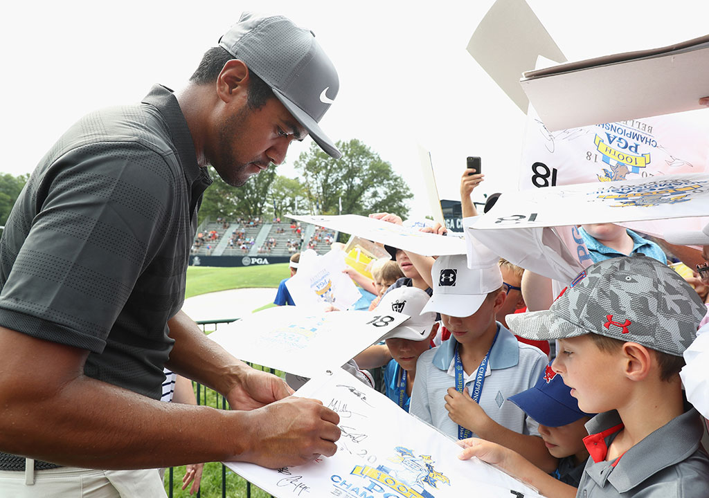 Tony Finau signs for fans during the 2018 PGA Championship.