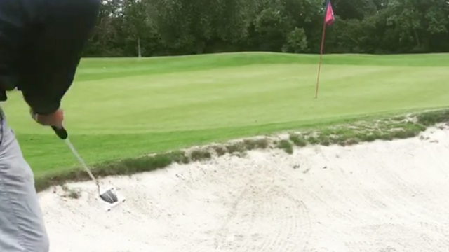 WATCH: Golfer putts ball through a bunker and into the hole