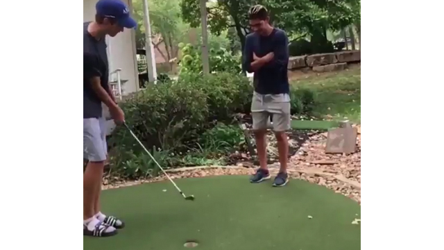 Watch: Golfer hits shot through friend's legs, over his head and into the cup